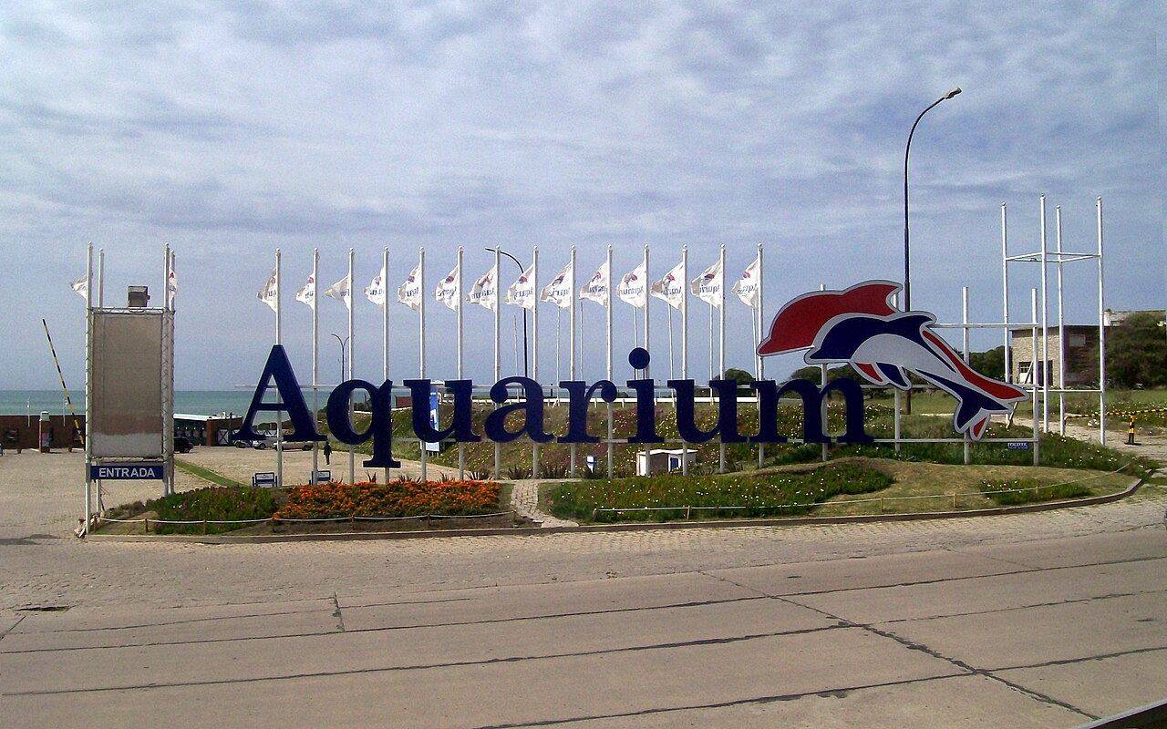 Entrada del Aquarium de Mar del Plata, con el nombre del establecimiento y banderas.