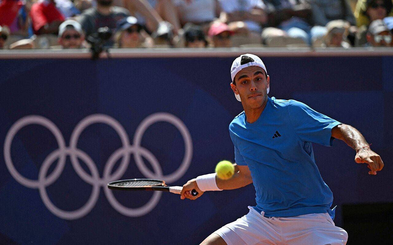 Francisco Cerúndolo jugando al tenis con una camiseta azul