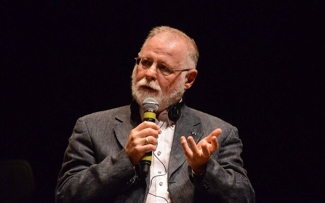 Alberto Manguel disertando con un micrófono en una conferencia