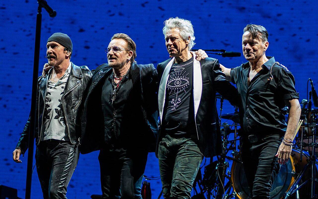 Los integrantes de la banda U2 caminando juntos en el escenario