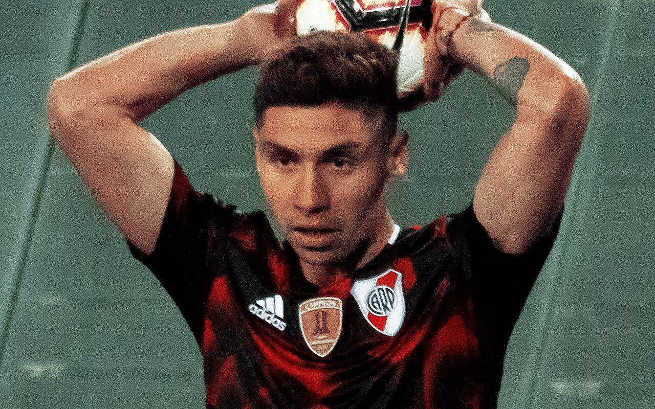Jugador de River Plate con la camiseta oficial sosteniendo la pelota