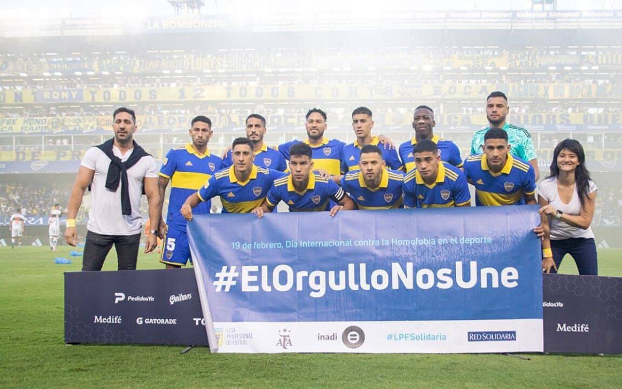 Equipo de Boca Juniors posando con una bandera de INADI