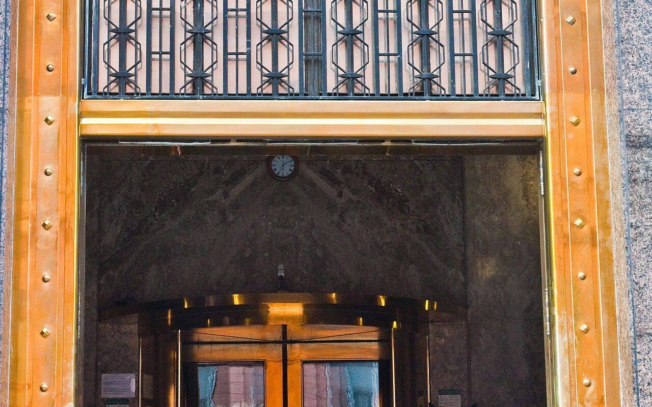 Entrada del Ministerio de Economía en Buenos Aires, con marco dorado y rejas metálicas.